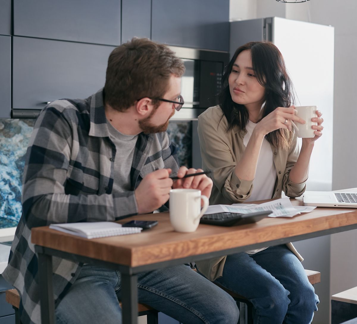 Two homeowners going through an electricity bill at their kitchen table