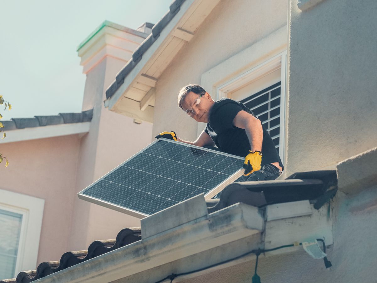Installer setting a solar panel onto a tile roof on a Bakersfield home